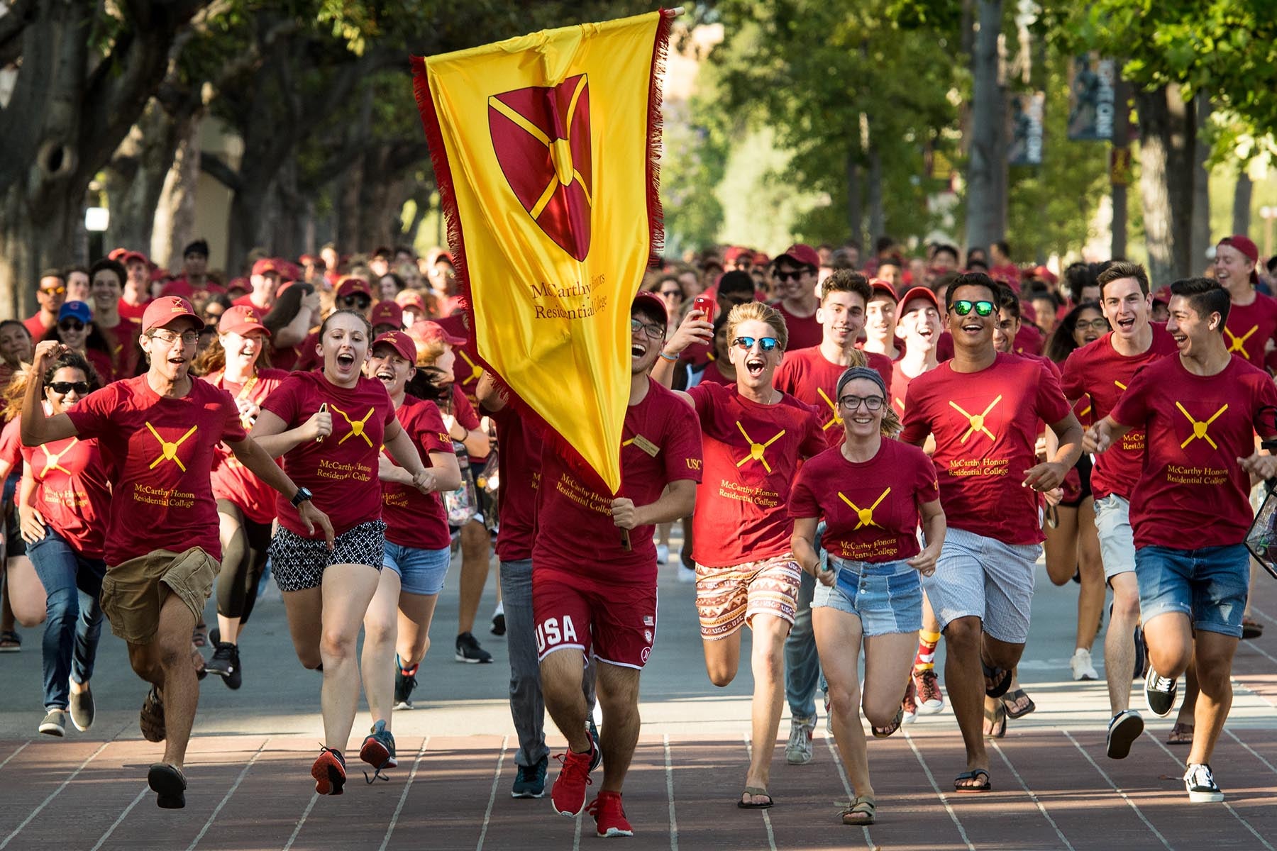 Students with collegiate crest running into pep rally