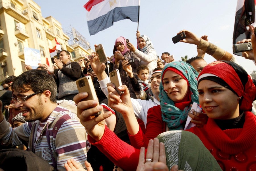 During the Arab Spring, Egyptians used their mobile phones to document unrest and celebrations. (MOHAMMED ABED/AFP/GettyImages)