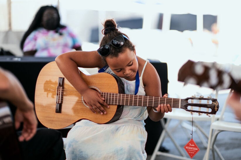 Music education: child plays guitar