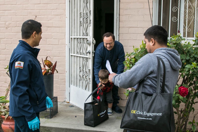 Eduardo Ibarra, right, and California State Assemblyman Miguel Santiago deliver to residents in Ramona Gardens