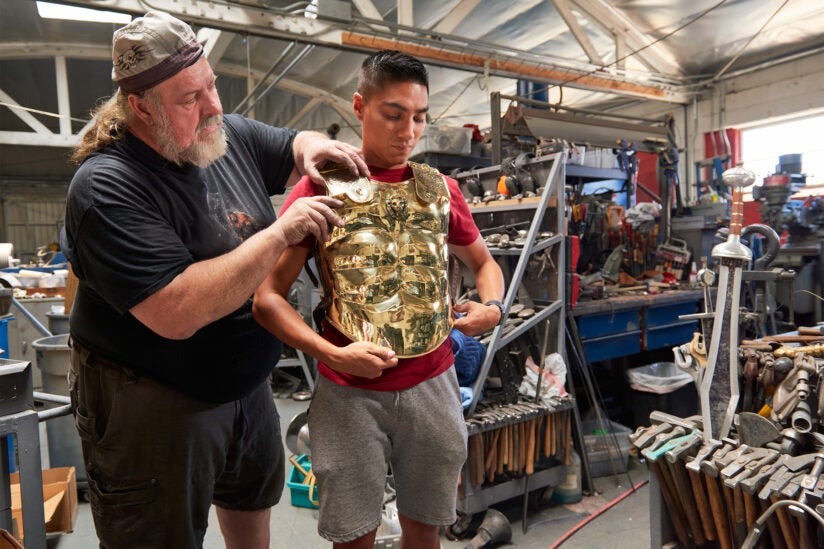 Tony Swatton makes adjustments to Jacobo Herrera’s armor