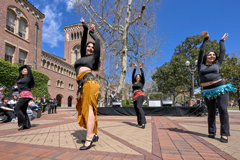 USC holds its largest Arab American Heritage Month celebration to date The Middle Eastern North African Student Assembly’s lively kickoff event in Hahn Plaza features music, Arab dance, inspiring stories and plenty of food. BY Greg Hernandez International relations sophomore Erika Chagin had no regrets about juggling her studies in recent weeks with rehearsals for an Arab dance. Her performance along with four other students dazzled a crowd of nearly 200 people during Monday’s Arab American Heritage Month kickoff event at Hahn Plaza on the University Park Campus¬¬. “Seeing such a nice turnout was really inspiring and very gratifying,” the USC Dornsife College of Letters, Arts and Sciences student said after the performance. “It felt really nice to represent my heritage in front of so many people and to be involved in what was only the second Arab American History Month at USC.” The lunchtime event was presented by the Middle Eastern North African Student Assembly (MENASA), which emphasizes unity and raising awareness about the Middle Eastern-North Africa region and diaspora. Attendees feasted on such foods as zaatar bread, spinach fatayer and baklawa — a Middle Eastern pastry similar to Greek baklava — as they watched performances and listened to remarks from USC President Carol L. Folt and other speakers. MENA students a growing presence at USC Folt pointed out that the university has nearly 800 students from 22 Middle Eastern and North African countries who identify as Arab or as Arab Americans. Among them is two-time Olympic swimmer Yusra Mardini, who is in her first year at the USC School of Cinematic Arts. Mardini is a refugee of the Syrian civil war and competed in the 2016 and 2020 Summer Olympics as a member of the Refugee Olympic Athletes Team and Refugee Olympic Team, respectively. Her life inspired the 2022 biographical film The Swimmers, which was distributed on Netflix. “Now she’s in the middle of building a foundation to bring education and sports opportunities to other refugees,” said Folt, who closed her remarks with a quote from Mardini: “‘Keep dreaming, no matter who says you can’t do it.’” Associate Professor Christine El Haddad of the USC Marshall School of Business, another featured speaker, said that the United States is home to more than 3.7 million Arab Americans who trace their origins to more than 20 countries in the Middle East and North Africa, including Lebanon, Syria, Jordan, Egypt, Saudi Arabia and the United Arab Emirates. She described Arab Americans as “an integral part of this nation” who have made important contributions to the United States across different fields, including literature, art, music, film, science, medicine, business and politics. “Today, we celebrate their achievements and rich heritage,” said El Haddad, who is from Lebanon. “I will always remember and be proud of my Arab roots. They are the foundation of my life and the wings to my future.” Making ‘good trouble’ The event’s keynote speaker, Amin Nash of the Arab American Civil Council, spoke about the struggle to establish the mile-long Little Arabia District in Anaheim and for the area to be officially recognized as a designated ethnic enclave. Approval from the Anaheim City Council finally came last August. Nash described the vote as “one of the most American things I’ve ever seen in my life.” “I knew that local and state governments struggle to imagine people from the Middle East and North Africa as a part of this country’s fabric,” he said. “We argued and we even talked back to the [council] to not ignore our community, to not erase us, to give us what this community has worked hard for. You could say that we made genuinely good trouble.” Nash shared that the battle in Anaheim was made more difficult because there is no MENA checkbox on official forms, which he said results in a lack of MENA demographic data and affects allocation of resources. He used his experience in Anaheim to encourage MENA students at USC to “imagine yourself as part of this campus, as part of this country’s fabric.” He applauded MENASA’s ongoing efforts to have a MENA checkbox added to university forms so Trojans of Arab descent would be able to check a box that reflects their heritage. “Because you are a part of this place, you do belong,” he said. “Your voice is important. Your voice matters. The truth is many people won’t think we exist until we show them.” Realizing their potential at Arab American Heritage Month celebration MENASA co-directors Anthony Khoory and Nour Myra Geha, the driving forces behind the creation of MENASA, called their 19-member executive board to the stage in the final moments of the event to bask in the success of what they have been able to accomplish in the past year. They first created an on-campus club for MENA students and successfully pushed for the Undergraduate Student Government to admit their club as its own assembly, complete with the funding, dedicated staff and other resources that come with that status. “We knew it was going to take a lot of time and a lot of hard work and a lot of effort,” said Geha, a USC Dornsife sophomore who grew up in Lebanon. “What we did not know is by building this up, we were going to be creating a community where real relationships are formed, where culture is shared and appreciated. We’re so thankful to be able to share this joy with you on a university level.” USC Dornsife senior Khoory closed the event by singing “Mawtini,” the national anthem of Iraq that is embraced across the Arab world. “It’s beautiful seeing all of you here,” he said to the crowd. “It’s a blessing how far this community has come on campus in the years since I was a freshman. I’m so thankful to God, who pushed us forward to really realize our potential.” The kickoff is part of a series of USC Arab American Heritage Month events that will include a community potluck, a talk on racial justice in the Middle East, a dabke dance night, a Sham El-Nessim celebration, and a concert with Egyptian singer and performer Bayou. The month will conclude with a formal ballroom event with speakers, performances and Arab American Heritage Month: belly dancers