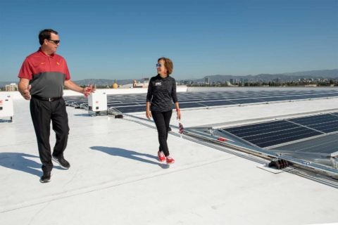 Mike Bohn and Carol L. Folt check out Galen Center solar panels