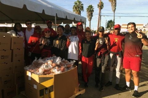 USC track and field team members take a break during Tuesday’s distribution of Thanksgiving turkeys and groceries