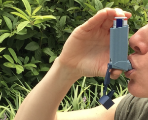 woman using an inhaler to control her asthma