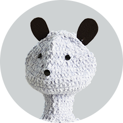 Blossom robot with a white knitted head and neck and black ears, eyes and nose