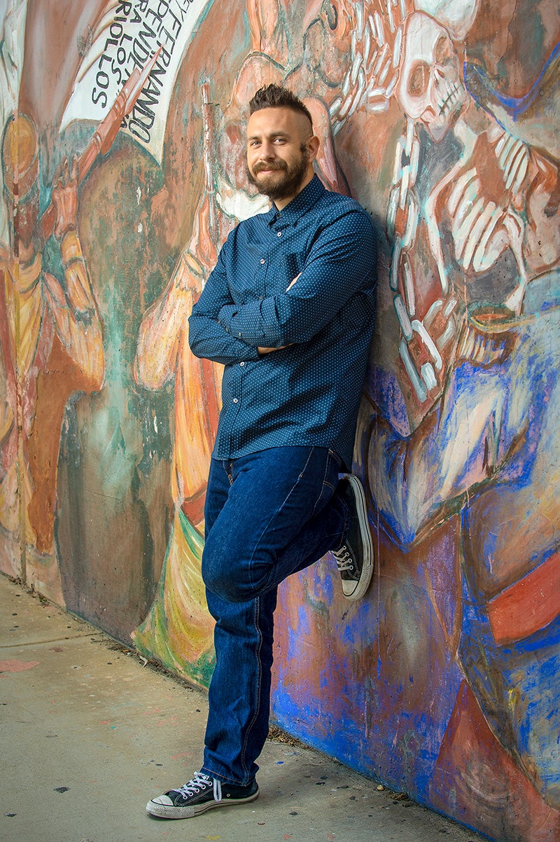 poet David Romero posed with mural