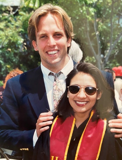 Catherine Barry in formal attire and a USC graduation sash and Tad Barry in a suit and tie.