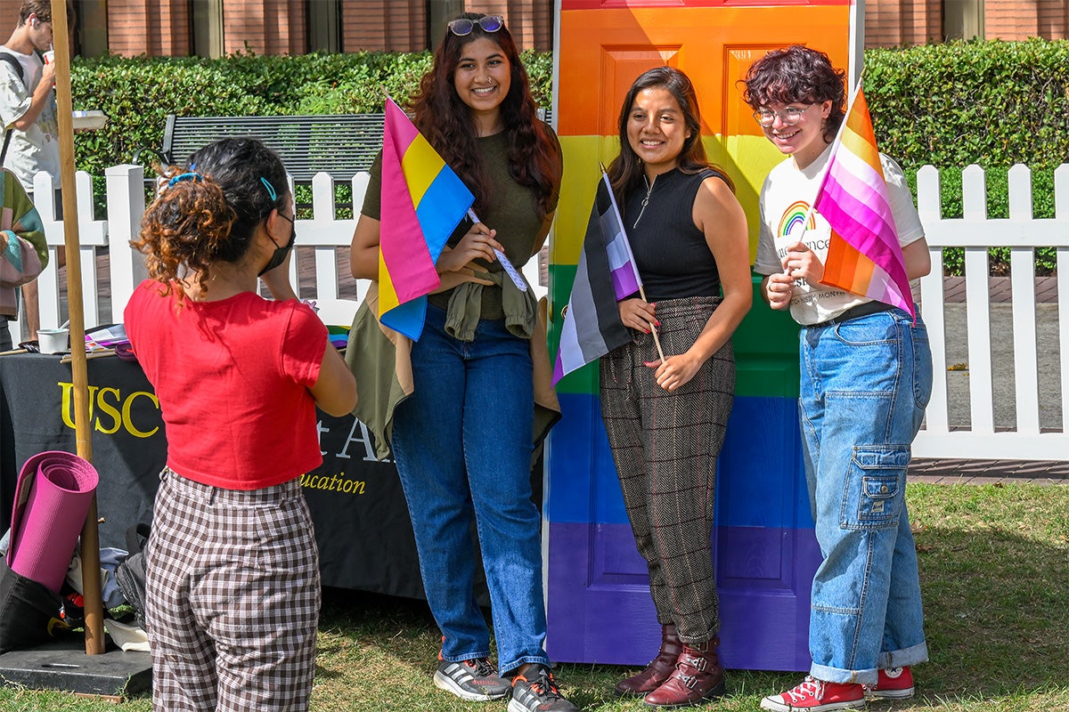 Amelia Jasti, Jazmin Gallegos, and Mel Persell pose for a picture at a photo booth.