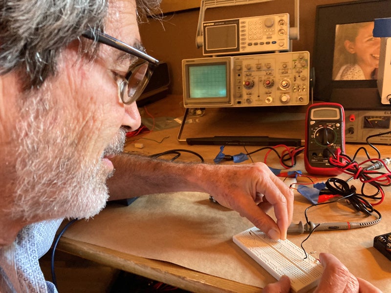 Professor Jack Feinberg uses a physics kit to build circuits for an online class in electricity and magnetism.