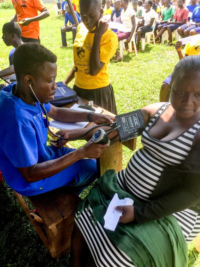 pharmacy student checking blood pressure of Uganda residents 