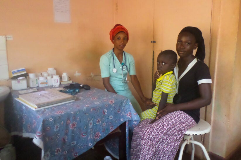 Health care worker with Gambia woman and her daughter attending the child health clinic.