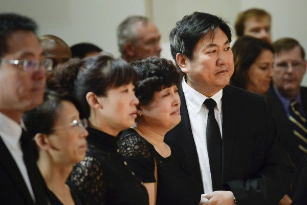 Xinran Ji's family, including father Songbo Ji, right, and Jinhui Dui, second from right, attend a service in memory of their son. (USC Photo/ Gus Ruelas)