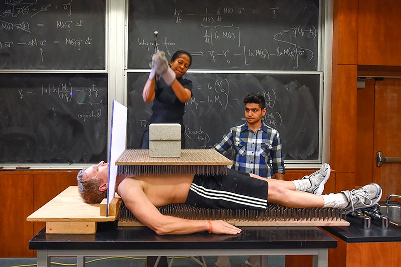 Physics professor Gene Bicker lays on a bed of nails to illustrate to his students a principal of physics, February 10, 2016. (USC Photo/Gus Ruelas)