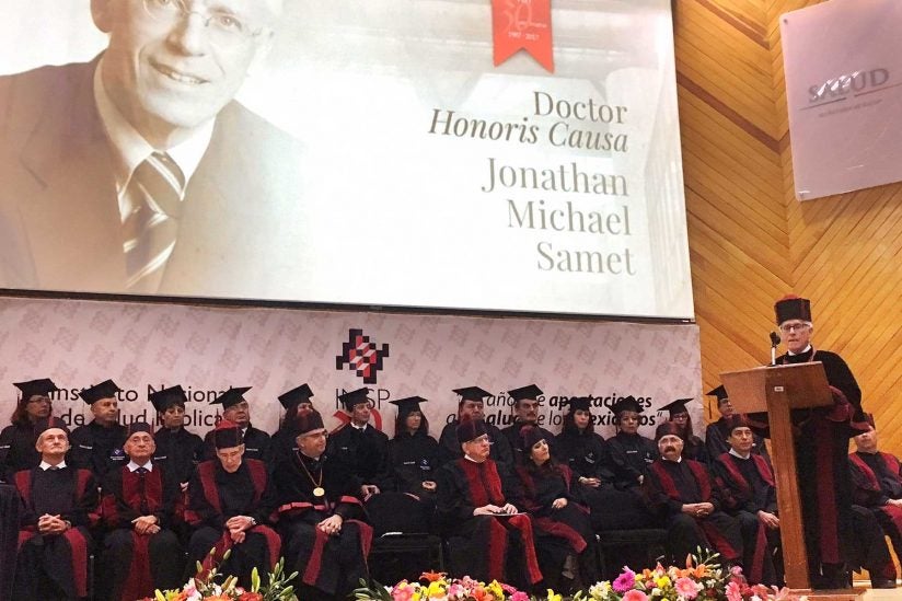 Jon Samet at podium next to fellow scholars