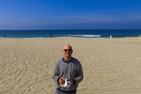 Portrait of Keith Plocek at the beach flying a drone