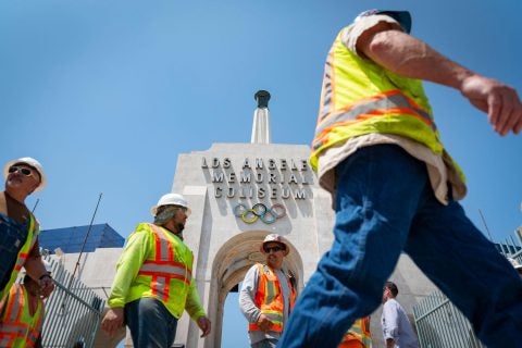 L.A. Coliseum renovation: workers pass the peristyle