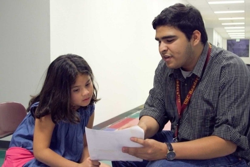 ReadersPlus volunteer coaching fifth grader