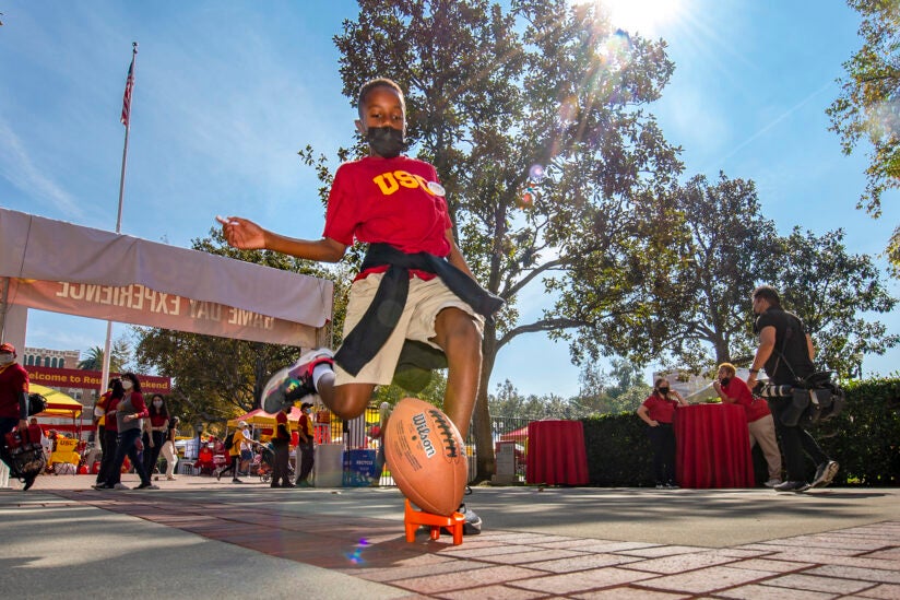 USC Reunion Weekend 2021: Youngster kicks a football at the USC Game Day Experience