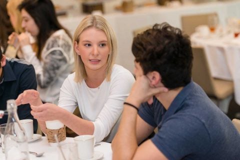 Students talking at a table for BAEP 460 class