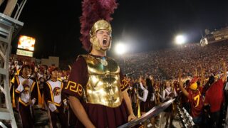Spirit of Troy supporter celebrating with USC Marching Band during football game