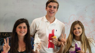 Three students posing with their 3D printer projects