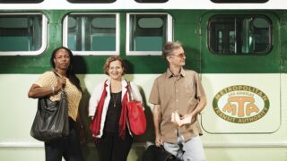 USC writers posing in front of a MTA bus