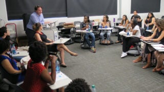 Professor lecturing to students in a classroom
