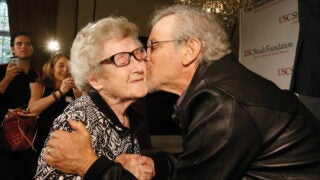 Steven Spielberg kissing an elderly women on the cheek