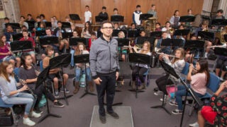 Music teacher with students playing instruments