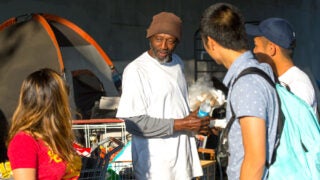 Student volunteers giving homeless food and water