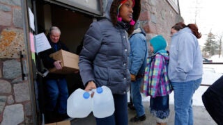 People collecting water jugs at water distribution