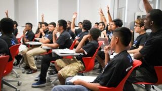Students raising their hands in the classroom