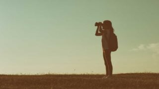 Girl looking out with binoculars