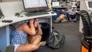 Girl under desk during Great Shakeout drill