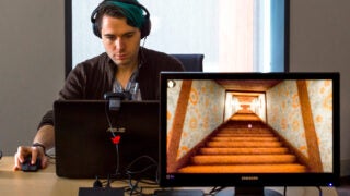 Man behind screen with headphones