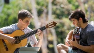 Two students playing guitars