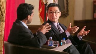 Two men speaking on panel