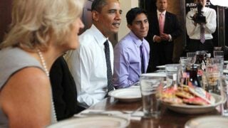Student sitting next to former President Obama at a lunch