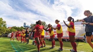 Womens soccer team high-fiving other players