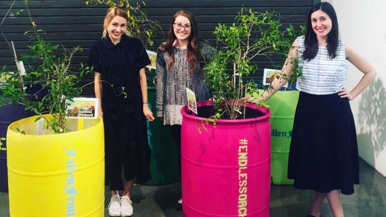 Students with plants in large buckets