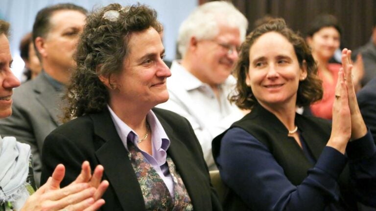 Woman smiling and people around her clapping