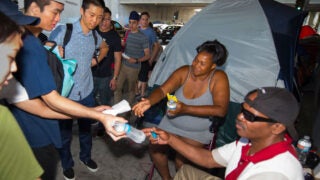 Students handing out water and meals to unhoused neighbors