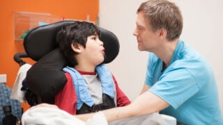 Caregiver with boy in wheelchair