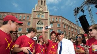 former usc president posing with students