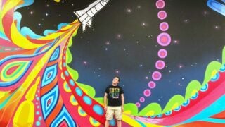 Joshua Fogel in front of mural