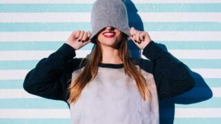 female pulling woolen hat over eyes