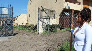 Nakea Brown looking at their old apartment building that is being redeveloped