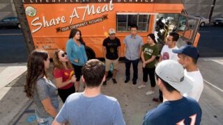 Food Truck with student volunteers around that is meant to feed the homeless