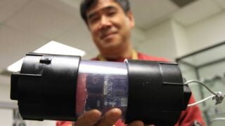 Wei-Min Shen holds an autonomous robot